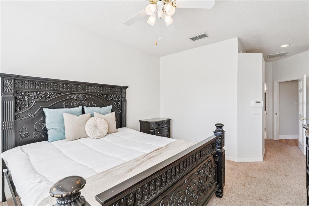 3823 Beacon Ridge Way Clermont, FL 34711 - Photo 30 of 57 a bedroom with a bed and a chandelier