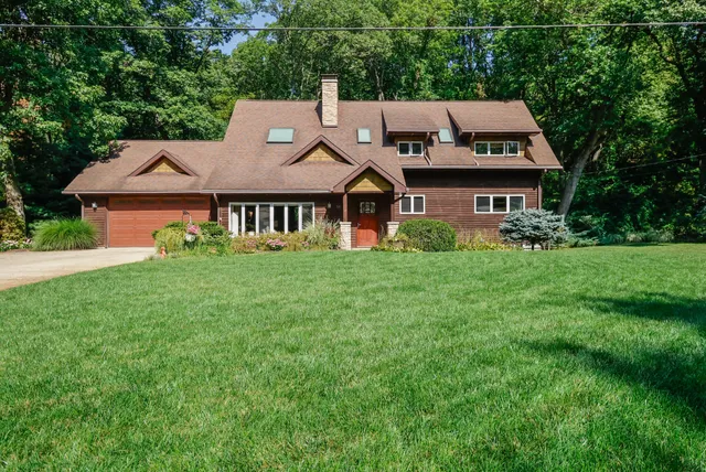 a aerial view of a house next to a big yard and large trees