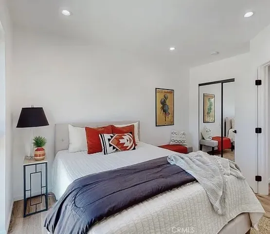 a bedroom with a bed and a lamp on dresser