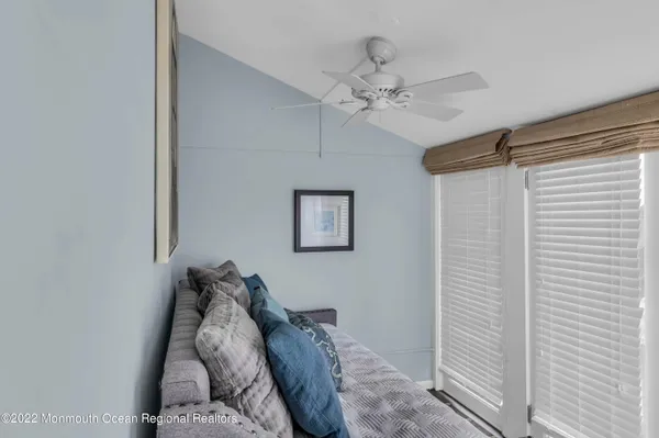 a bedroom with a bed and a chandelier fan
