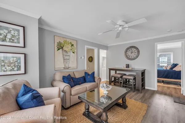 a living room with furniture a clock on wall and a fireplace