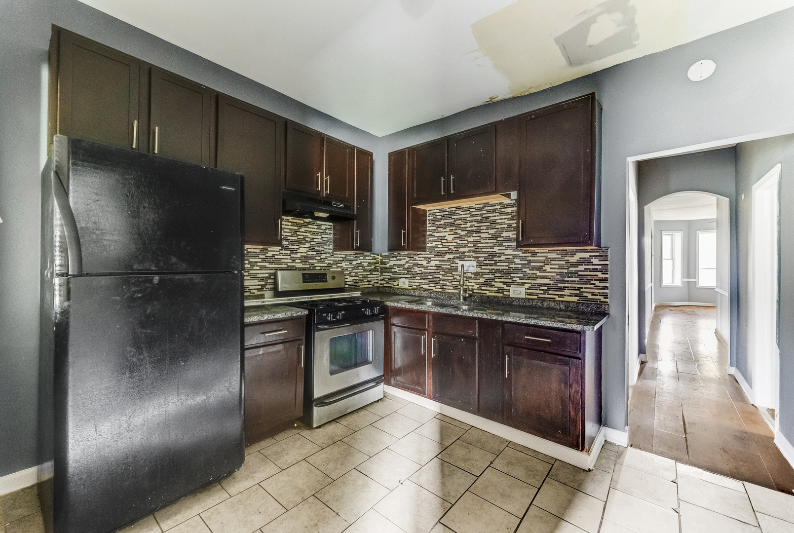 6601 South St Lawrence Avenue Chicago, IL 60637 - Photo 11 of 29 a kitchen with granite countertop stainless steel appliances and wooden cabinets