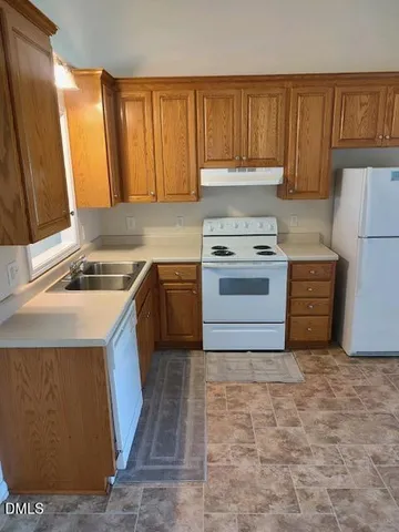 a kitchen with a stove sink and cabinets