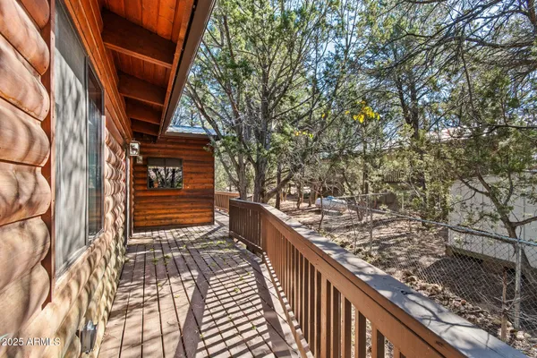 a view of balcony with wooden floor and fence and a bench
