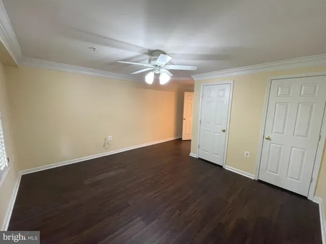 an empty room with a ceiling fan and a window