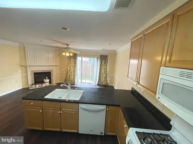 a kitchen with granite countertop a sink stove and cabinets