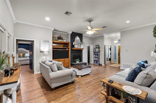 a living room with furniture kitchen view and a wooden floor