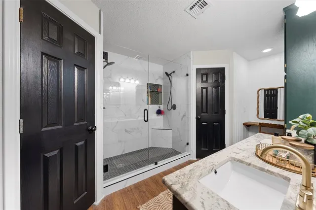 a bathroom with a granite countertop sink mirror and shower
