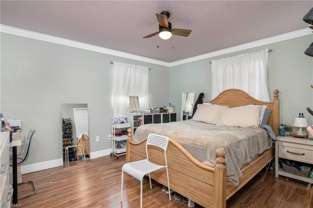 5350 Catts Street Naples, FL 34113 - Photo 13 of 21 a bedroom with a bed a chandelier and dresser
