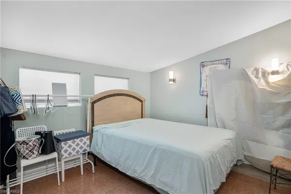 a bedroom with a bed chair and wall painting