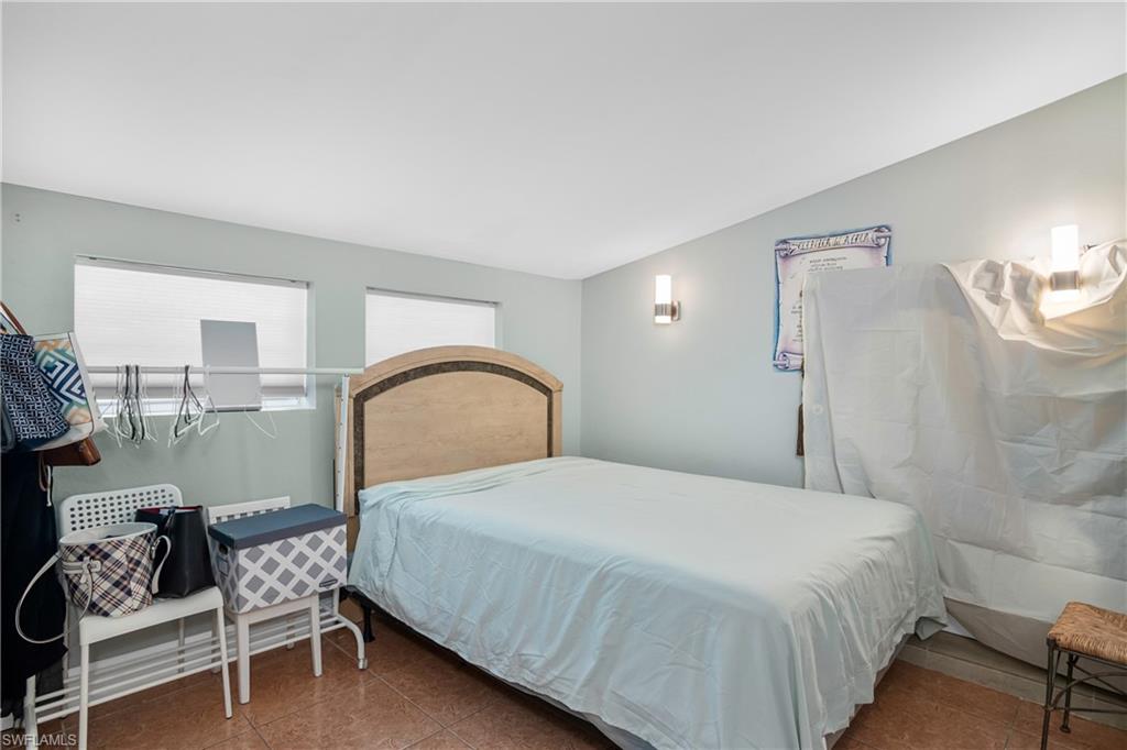 5350 Catts Street Naples, FL 34113 - Photo 16 of 21 a bedroom with a bed chair and wall painting