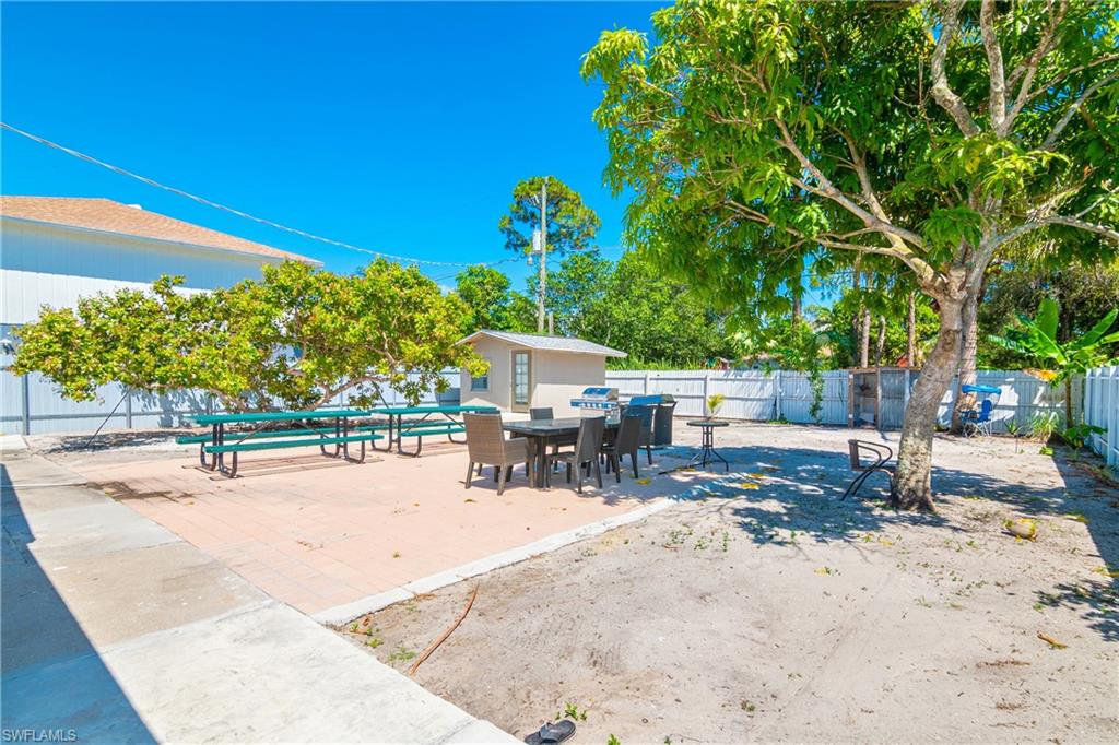 5350 Catts Street Naples, FL 34113 - Photo 18 of 21 a view of a patio with a table and chairs under an umbrella