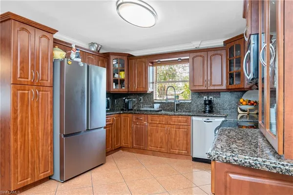 a kitchen with stainless steel appliances granite countertop a refrigerator and a sink