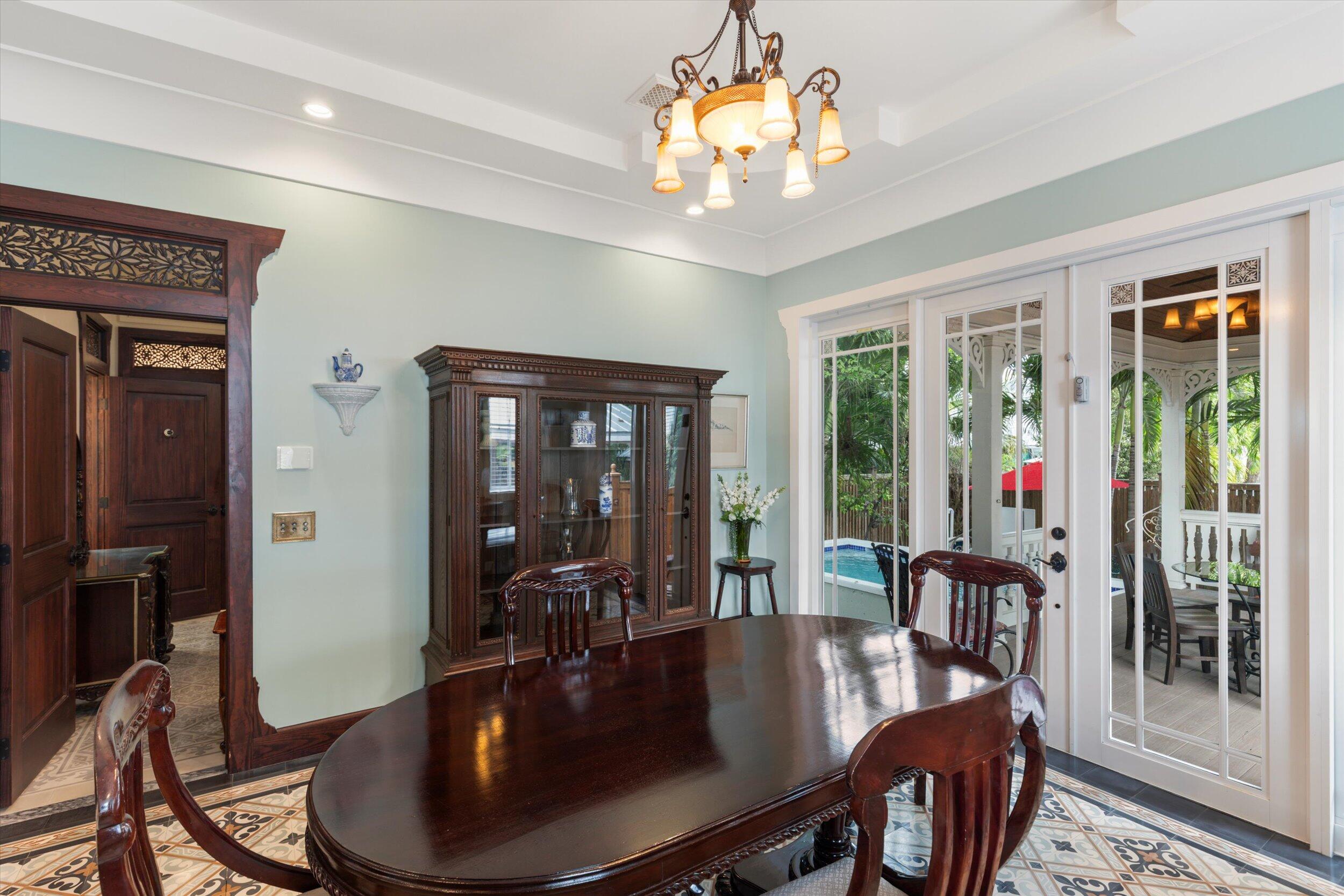 512 Amelia Street Key West, FL 33040 - Photo 15 of 52 a view of a dining room with furniture wooden floor and chandelier