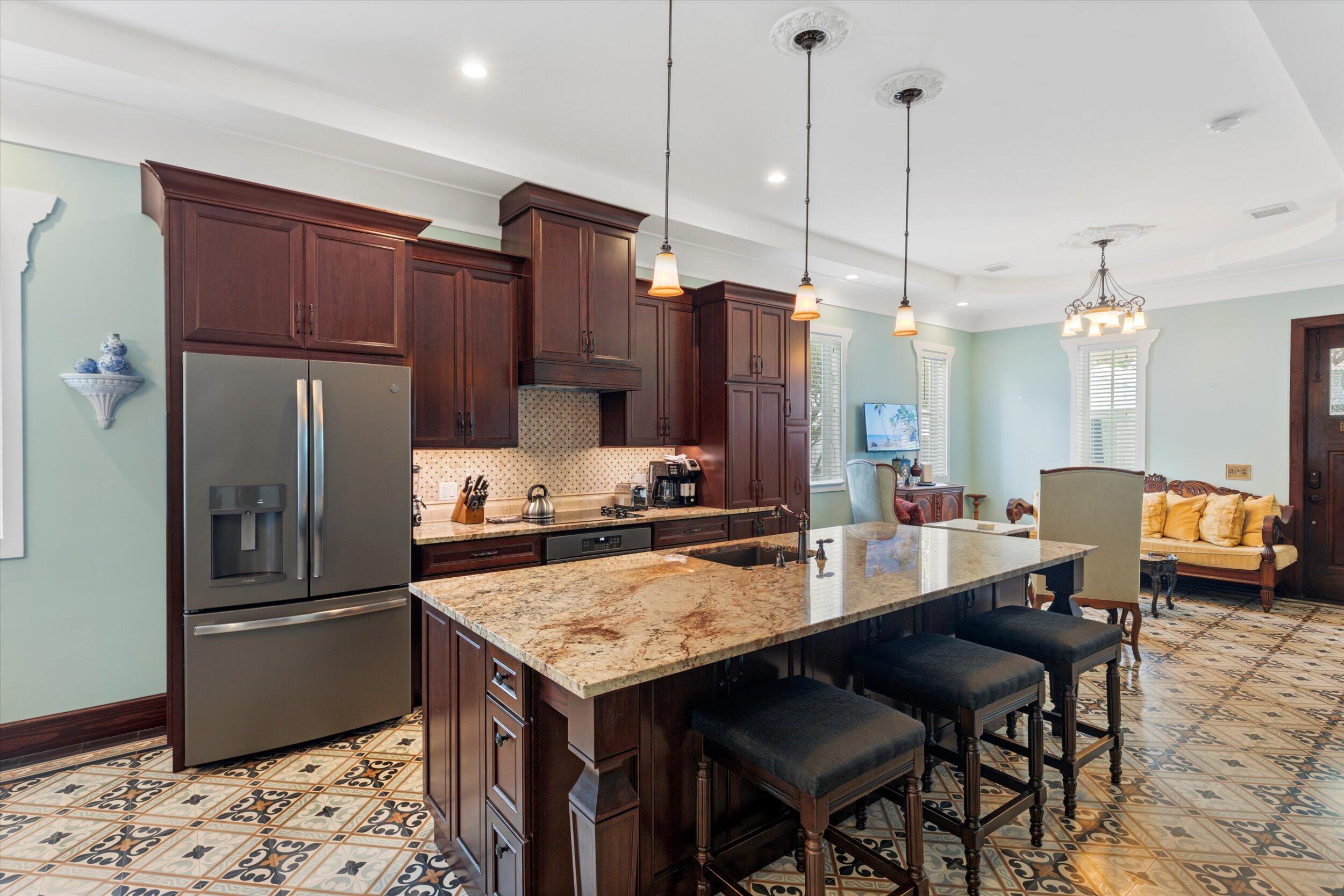 512 Amelia Street Key West, FL 33040 - Photo 18 of 52 a kitchen with granite countertop a table chairs stainless steel appliances and wooden floor