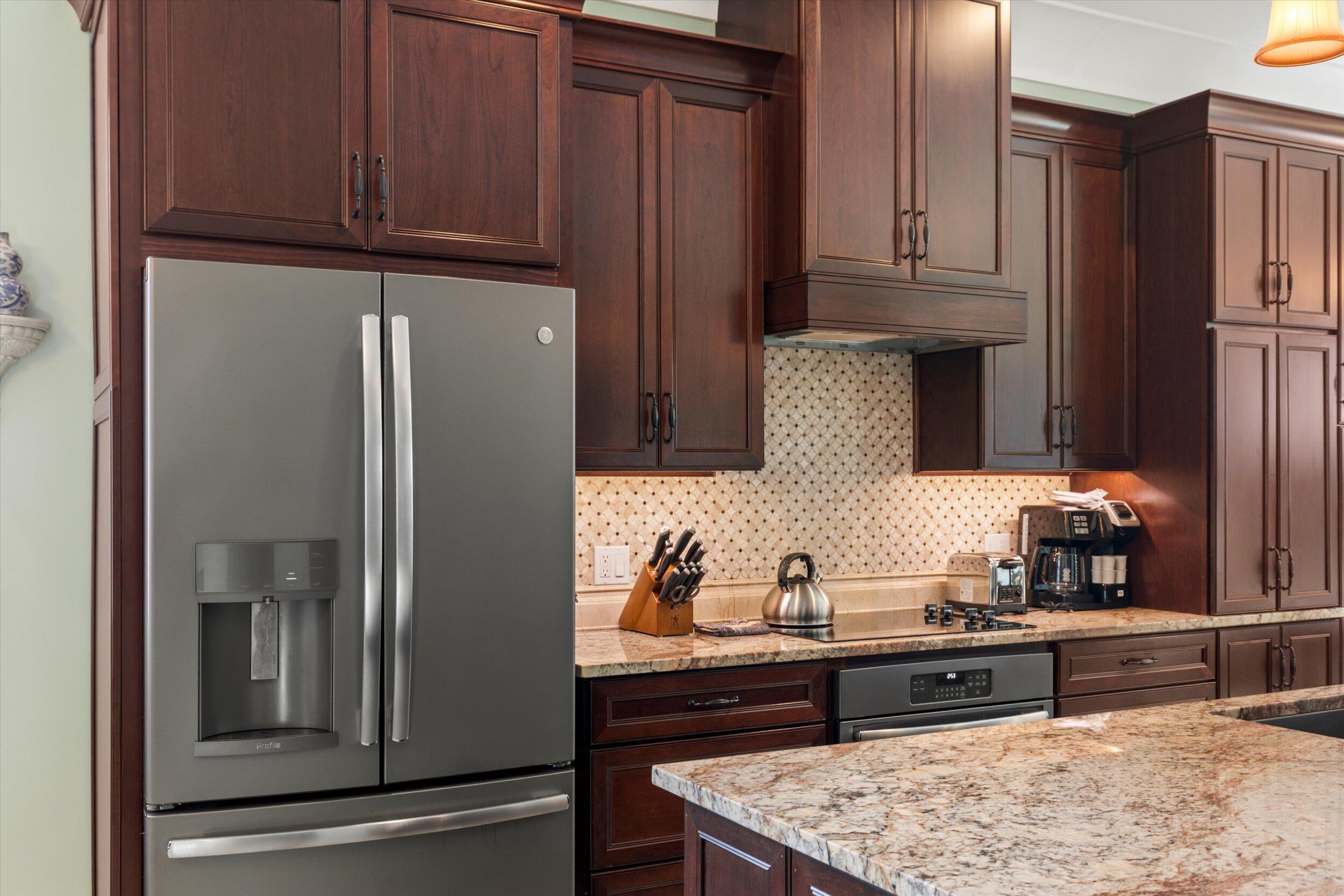 512 Amelia Street Key West, FL 33040 - Photo 34 of 52 a kitchen with granite countertop a refrigerator and cabinets