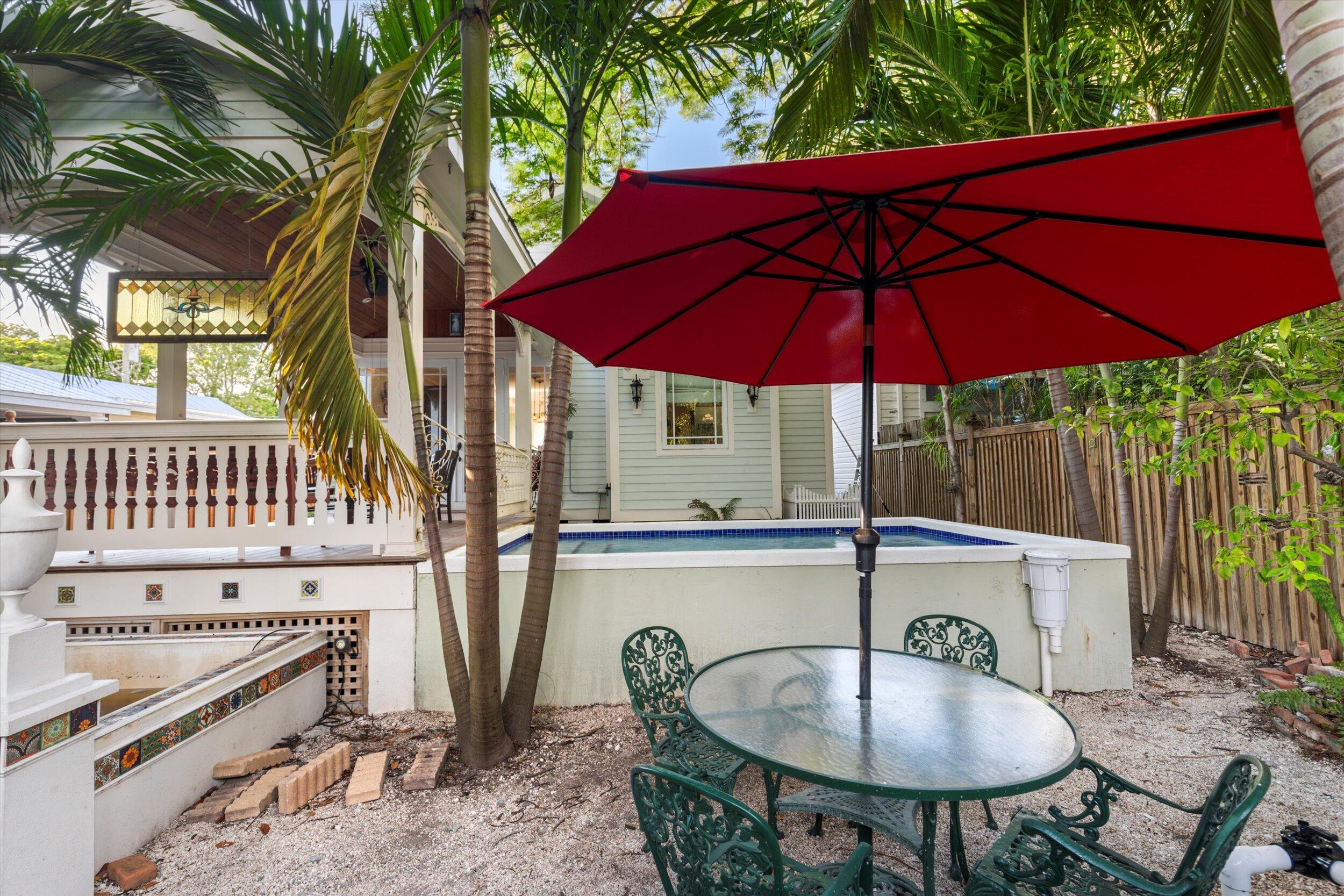 512 Amelia Street Key West, FL 33040 - Photo 48 of 52 a balcony with table and chairs under an umbrella
