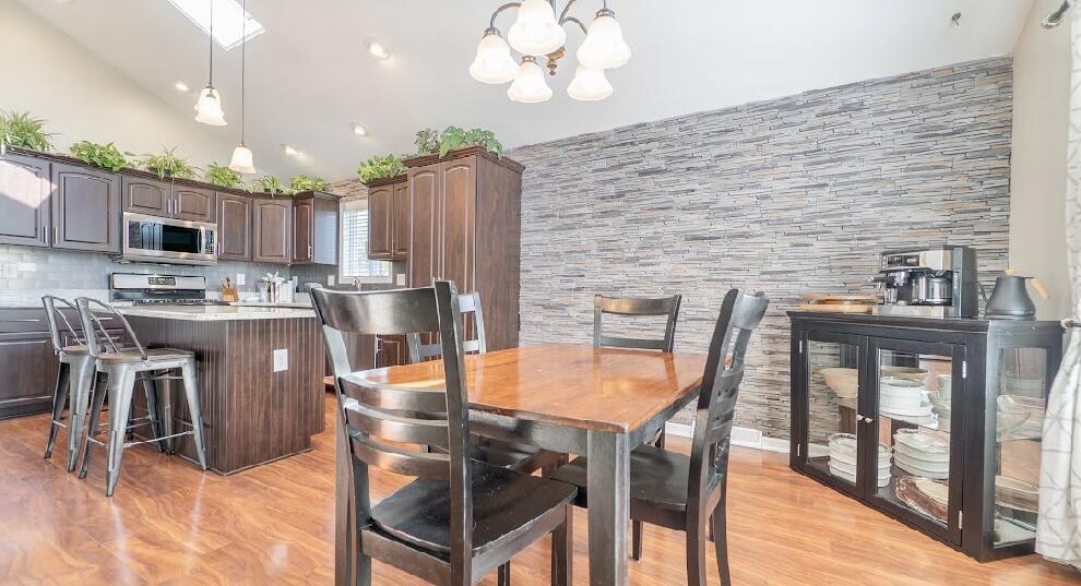9166 Maple Court St. John, IN 46373 - Photo 13 of 40 a dining room with stainless steel appliances a table chairs and chandelier