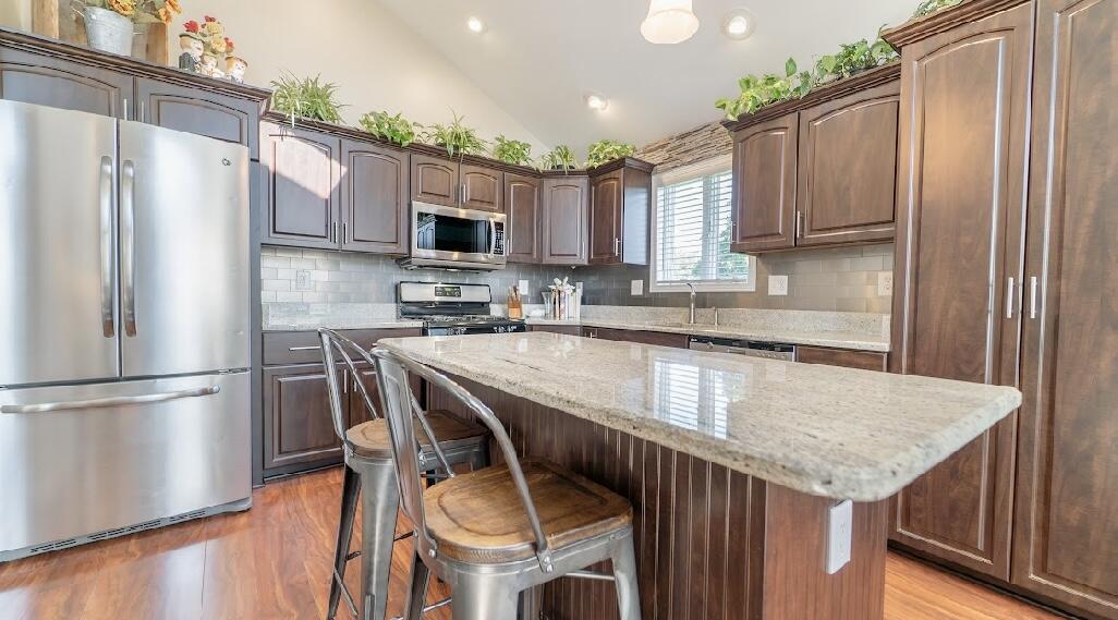 9166 Maple Court St. John, IN 46373 - Photo 15 of 40 a kitchen with stainless steel appliances granite countertop a refrigerator a sink dishwasher a stove a microwave oven with cabinets and wooden floor