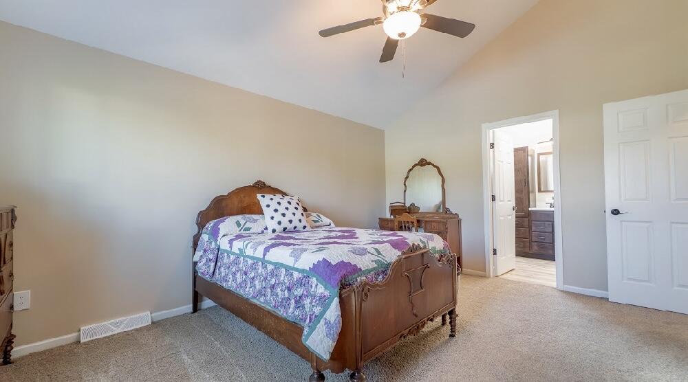 9166 Maple Court St. John, IN 46373 - Photo 19 of 40 a bedroom with a bed and a chandelier
