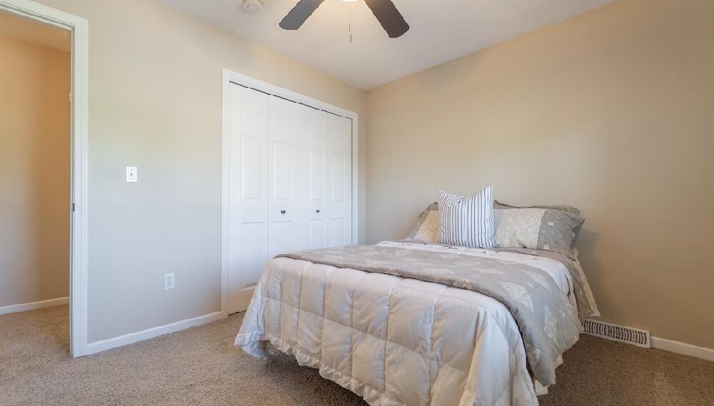 9166 Maple Court St. John, IN 46373 - Photo 21 of 40 a bedroom with a bed and a chandelier fan