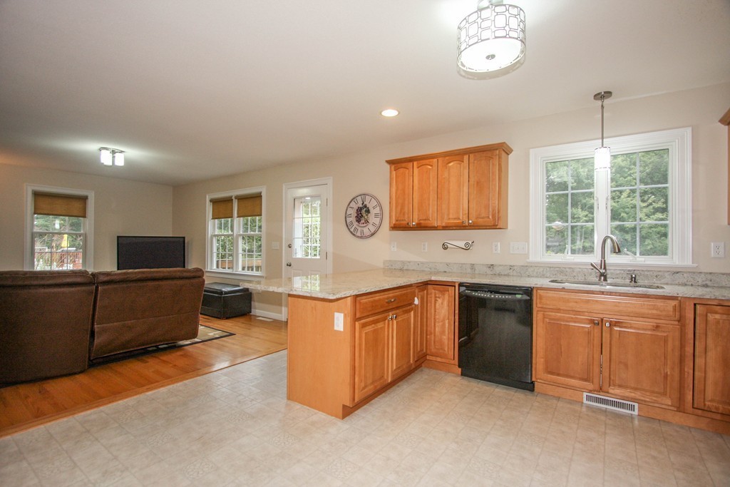 49 Chester Street West Springfield, MA 01089 - Photo 11 of 25 a large kitchen with stainless steel appliances granite countertop a sink and dishwasher a stove with wooden floor