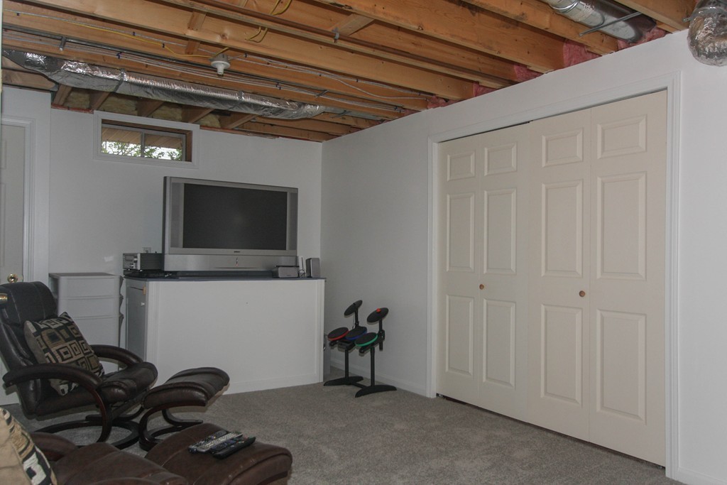 49 Chester Street West Springfield, MA 01089 - Photo 23 of 25 a living room with furniture a flat screen tv and gym equipment