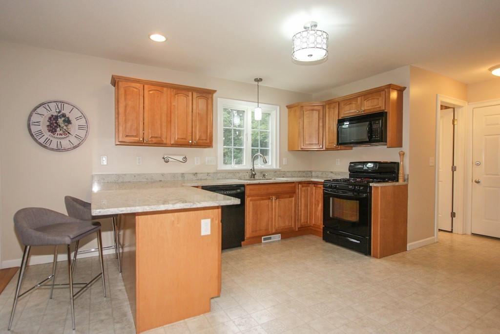 49 Chester Street West Springfield, MA 01089 - Photo 10 of 25 a kitchen with granite countertop a stove a sink and a refrigerator