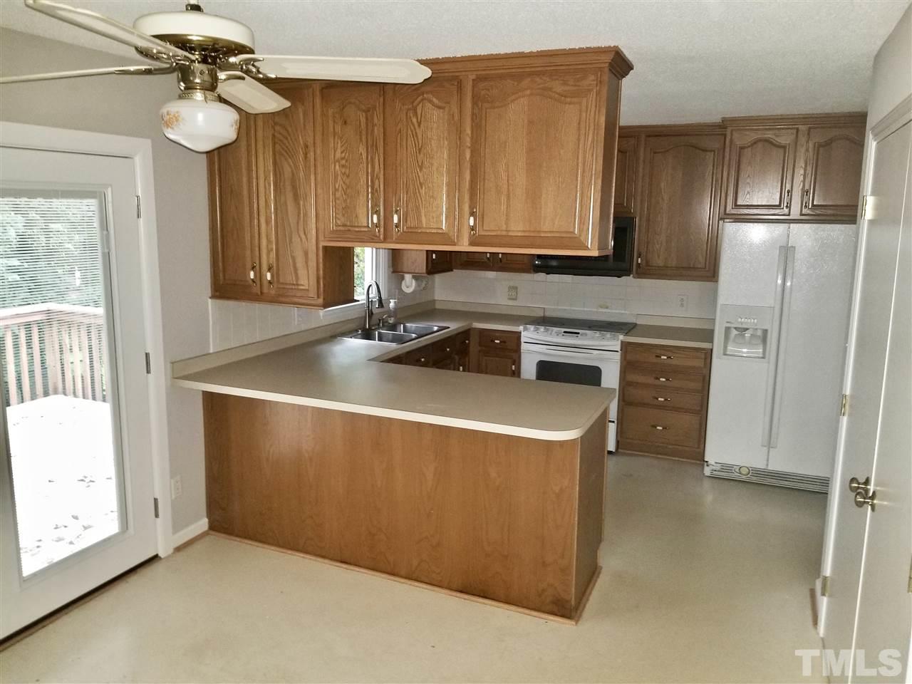 6420 Rockrest Court Raleigh, NC 27612 - Photo 4 of 22 Upper level eat-in kitchen w/ sliding door access to rear deck - appliances convey