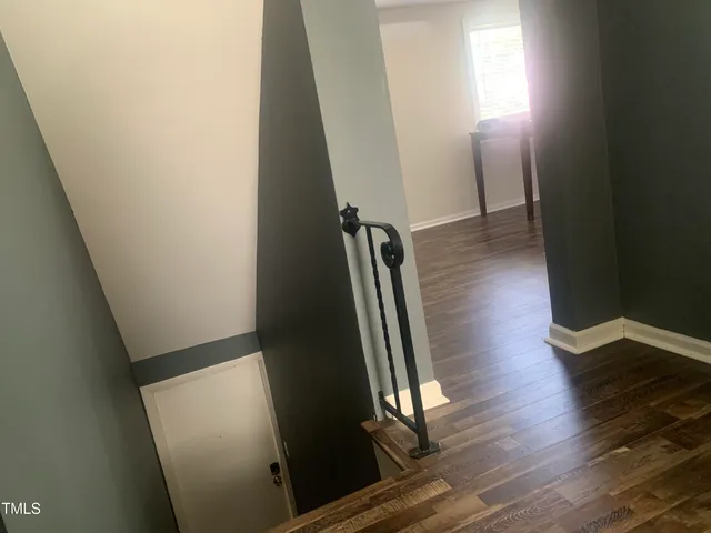 a view of a hallway with wooden floor and staircase