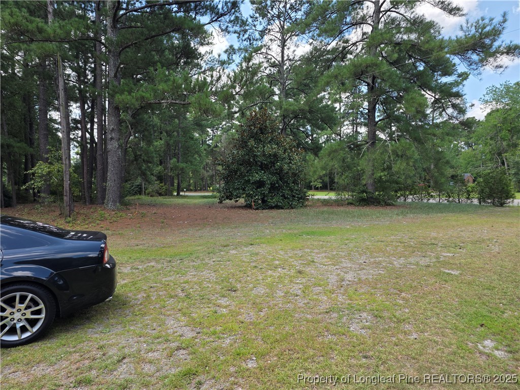 6405 Cedar Creek Road Fayetteville, NC 28312 - Photo 5 of 6 a view of a yard with a car parked