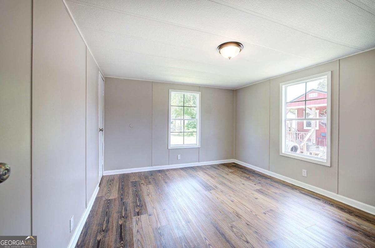 50 Tency Lane Northeast Rome, GA 30165 - Photo 10 of 23 an empty room with wooden floor and windows