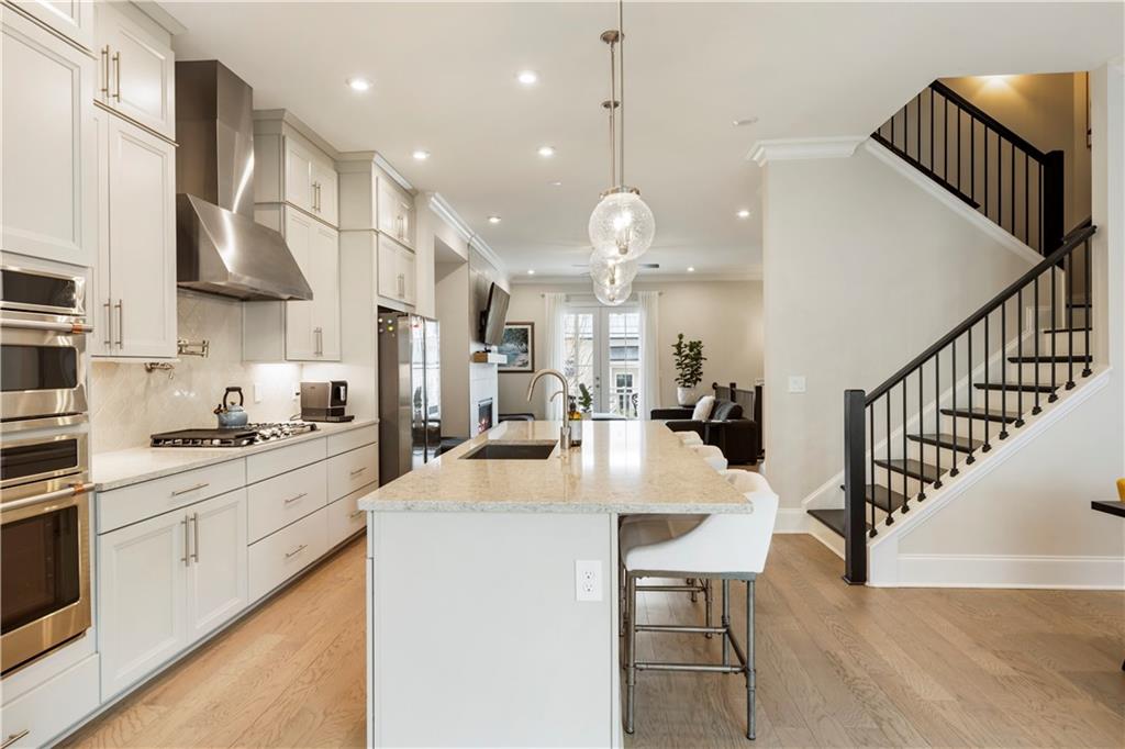 884 Mayfield Road Milton, GA 30004 - Photo 8 of 20 a kitchen with stainless steel appliances kitchen island a table chairs sink and cabinets