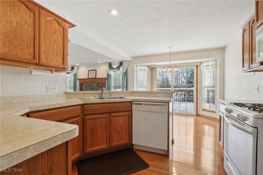 15139 Timber Ridge Drive Middlefield, OH 44062 - Photo 13 of 44 Oak Kitchen Featuring Recessed Lighting, White Appliances, Sink, Hardwood floors, and Breakfast Bar