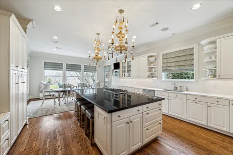 a kitchen with a sink stove and wooden floor