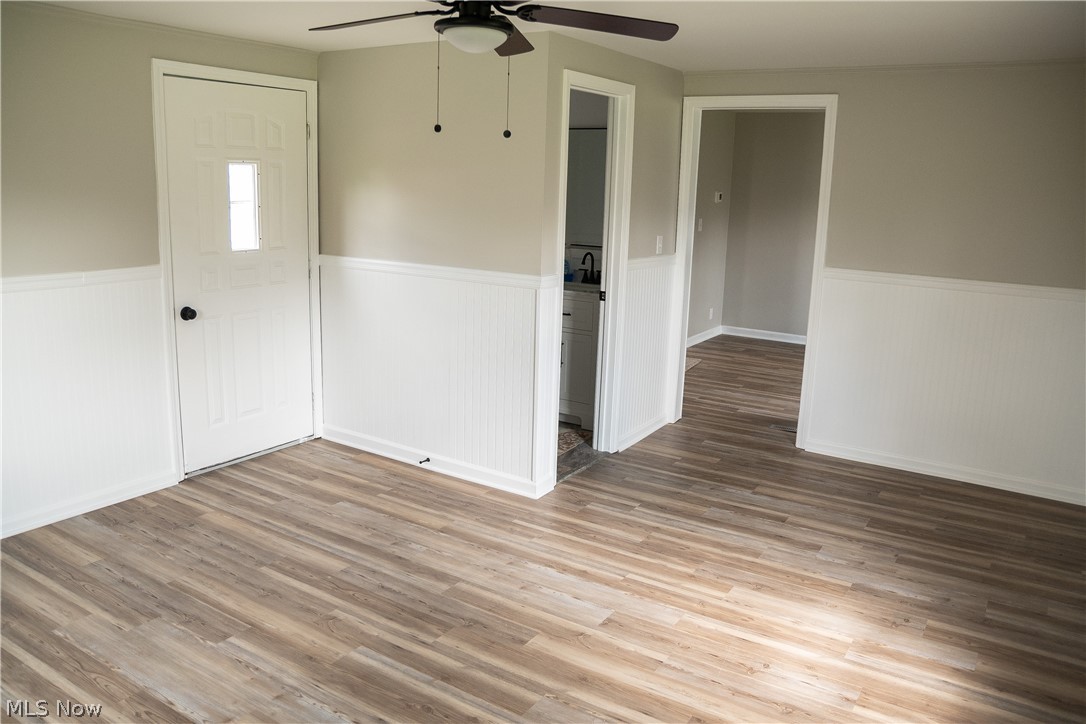 6666 Clingan Road Youngstown, OH 44514 - Photo 26 of 41 Family room with new ceiling fan, wainscoting, hald bathroom and exit to back patio