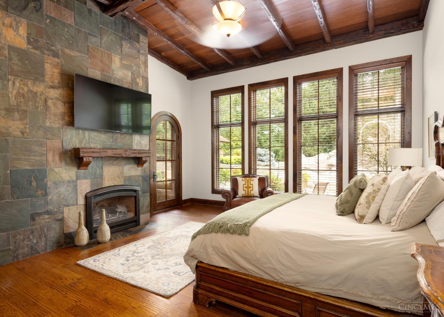 5900 Park Road Cincinnati, OH 45243 - Photo 18 of 50 First Floor Owners’ Suite (19’ X 16’) This first floor owners’ suite features hardwood flooring, beamed ceiling, stone wall with inset gas fireplace, wall-of-windows view, and walkout to pool and spa.