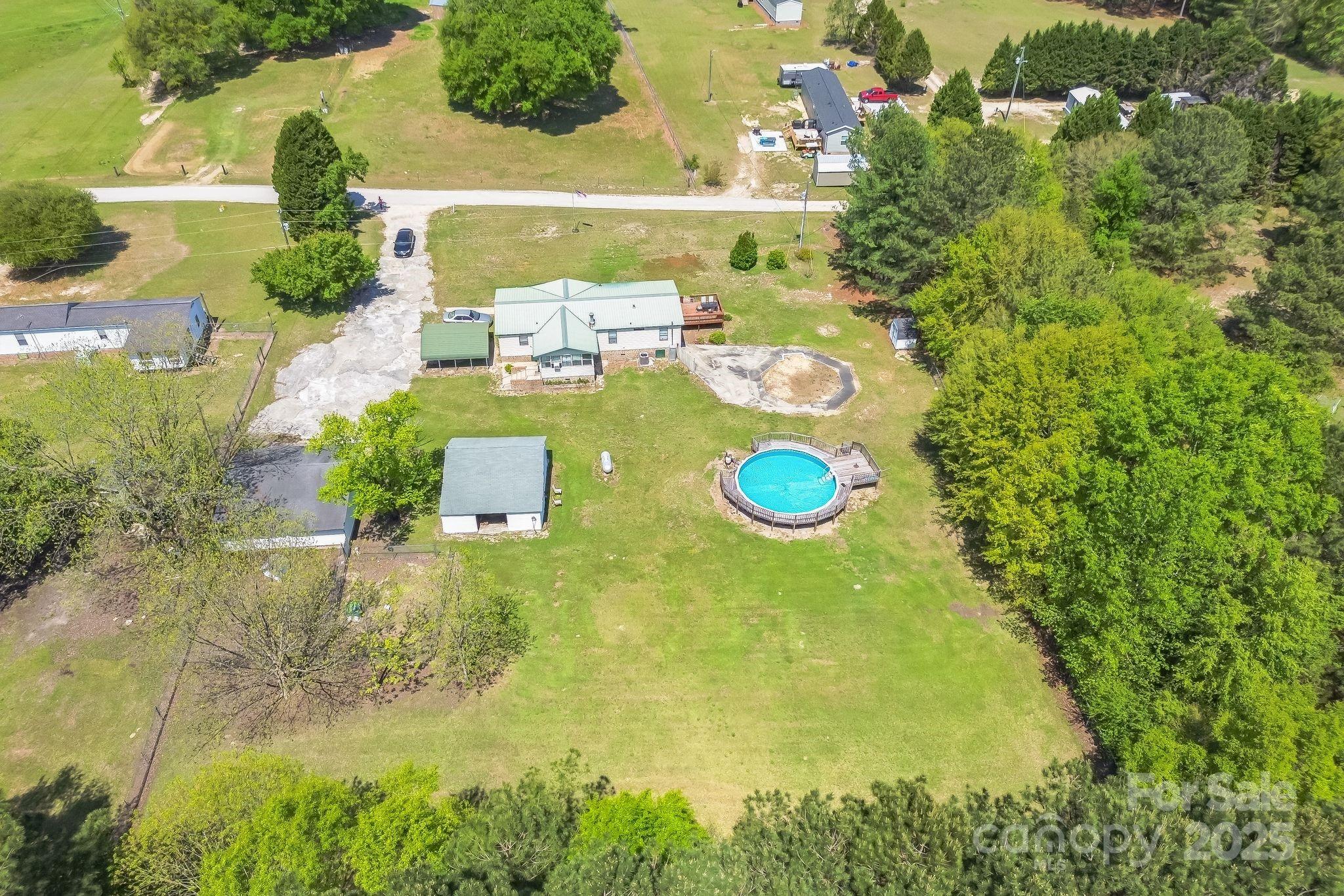 164 Phelps Road Chesterfield, SC 29709 - Photo 21 of 27 a view of a swimming pool with some plants and large trees