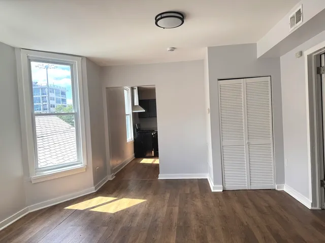 an empty room with closet and windows