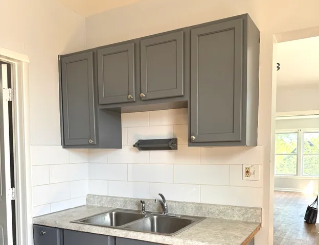 a kitchen with granite countertop white cabinets and sink