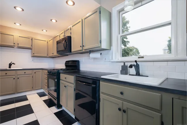 a kitchen with a sink window and cabinets