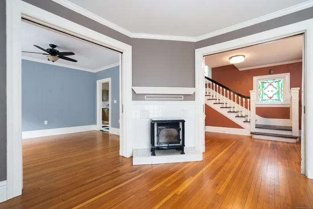 a view of a livingroom with wooden floor and a fireplace