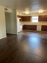 2507 Stella Street, Unit A Denton, TX 76201 - Photo 1 of 5 a view of kitchen and empty room with wooden floor