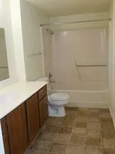 a bathroom with a granite countertop sink toilet and shower