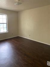 2507 Stella Street, Unit A Denton, TX 76201 - Photo 3 of 5 an empty room with wooden floor and windows