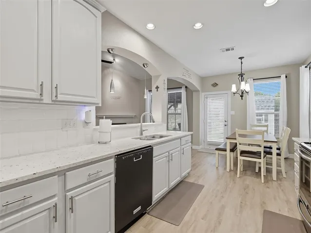 a kitchen with granite countertop a sink dining table and chairs