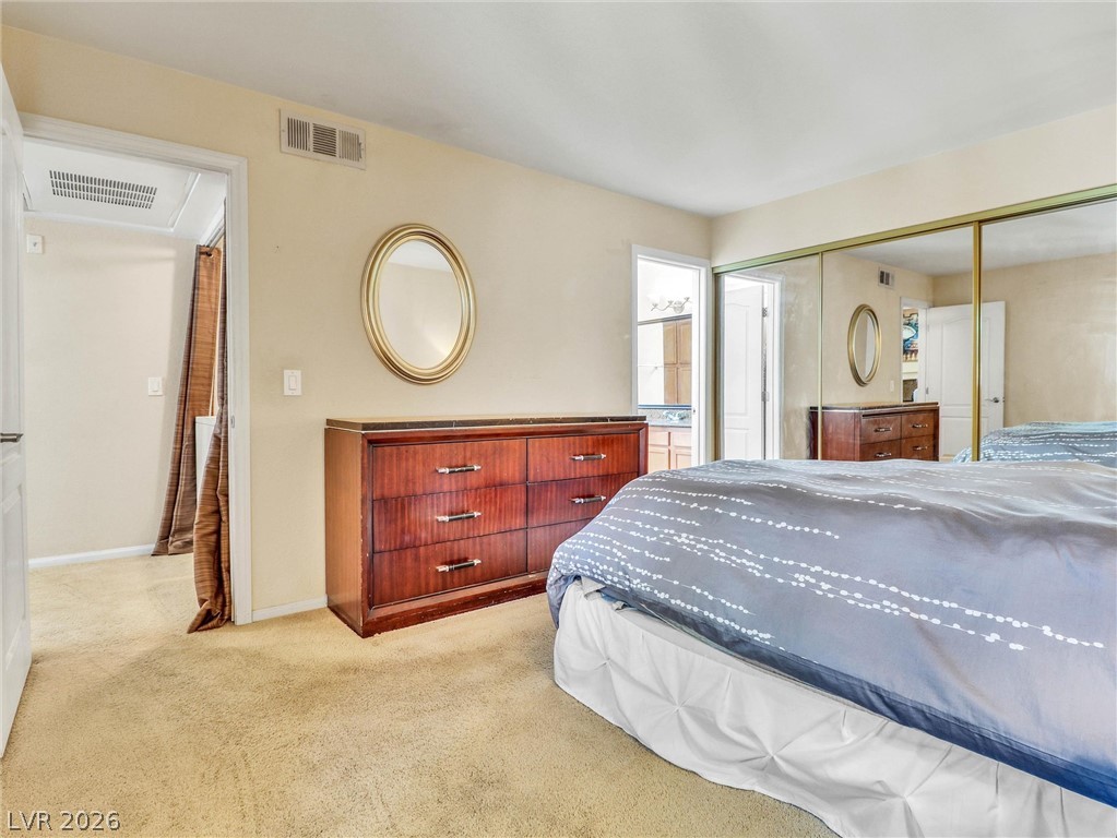 3145 East Flamingo Road, Unit 2129 Las Vegas, NV 89121 - Photo 17 of 43 A well-lit bedroom features ample storage with mirrored closet doors and warm carpet flooring.