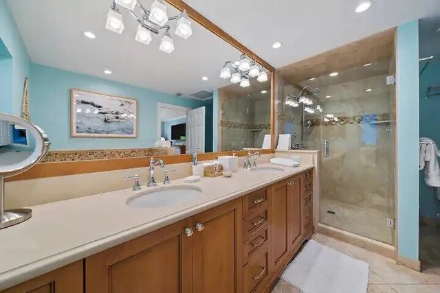 a spacious bathroom with a sink a large mirror and a shower