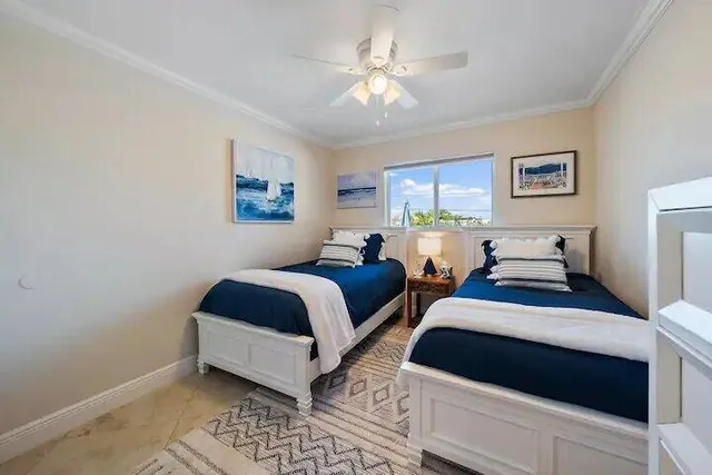 a bedroom with two beds and a window