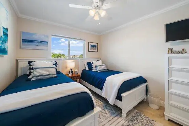 a bedroom with two beds and a flat screen tv